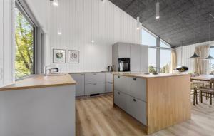 Una cocina con gabinetes blancos y una ventana grande. en Cozy Home In Knebel With Sauna, en Ørby