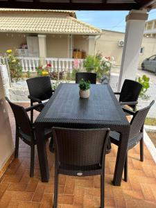 a black table with chairs and a potted plant on a patio at Christodoulos Villa in Agios Georgios