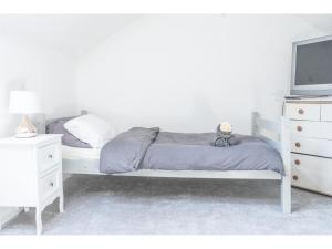 a white bedroom with a bed and a tv at Spacious Pad - Close to Sports Village, Leigh Market, Mesnes Park - Parking - Wifi in Leigh