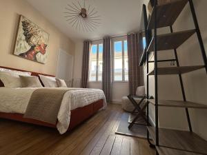 ein Schlafzimmer mit einem Bett und einer Leiter darin in der Unterkunft LE PALAIS DE LEO Luxury Apt Epernay Hyper center 4P Balcony AC in Épernay