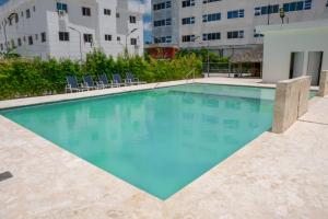 una piscina con acqua blu in un edificio di Hotel Gran Real Punta Cana a Punta Cana
