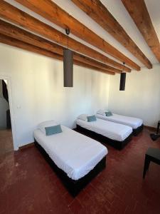 two beds in a room with wooden ceilings at Les Combres in La Daguenière