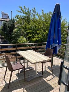 a table and chairs and a blue umbrella on a deck at Enn Is Inn Hotel in Marmaraereglisi
