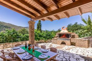 a patio with a table and a pizza oven at Villa Thalassia by Villa Plus in Kassiopi