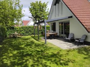 a patio with a picnic table and chairs in a yard at Vakantiepark Eysinga State Huize Anna in Sint Nicolaasga