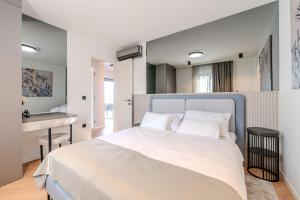 a bedroom with a large white bed and a desk at La Vir deluxe- Silver & Black in Vir