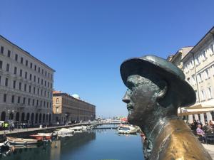 Une statue d'une femme dans un chapeau à côté d'un canal dans l'établissement Lo Studio di Joyce, à Trieste