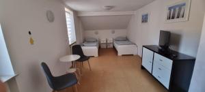 een klein appartement met een woonkamer met een tv en stoelen bij Arzberger Monteurhaus in Arzberg