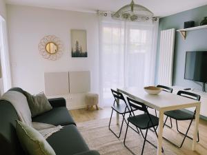 a living room with a table and a couch at Jeannette's House in Magny-le-Hongre