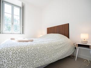 a white bedroom with a bed and a window at La Sérénade des Mauges Charme Nature Détente in Montfaucon