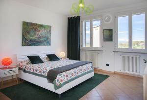 a bedroom with a bed in a room with windows at Villa Bricco Astiani in Montegrosso dʼAsti