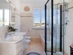 a bathroom with two sinks and a toilet and a shower at Villa Bricco Astiani in Montegrosso dʼAsti