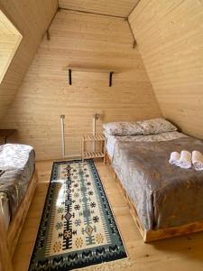 a room with two beds and a rug in a attic at Guesthouse Venera in Mestia