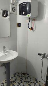 a bathroom with a sink and a tv on the wall at Cozy House in Hanoi