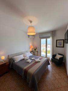 a bedroom with a bed and a chair and a window at 420 rooms in Pachino
