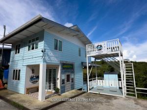 a blue building with a ladder in front of it at Qloud Cottage Kundasang in Ranau