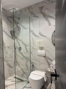 a bathroom with a toilet and a glass shower at Villa La Mer Durres in Durrës +69 photos