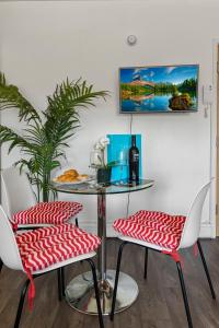 a table and two chairs with red and white seats at City Centre Studio Apartments - Baxter Apartment - Short Stays UK Ltd in Exeter