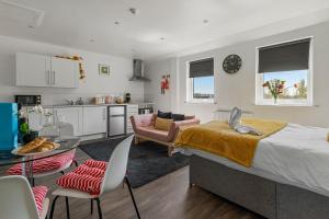 a bedroom with a large bed and a kitchen at City Centre Studio Apartments - Baxter Apartment - Short Stays UK Ltd in Exeter +9 photos