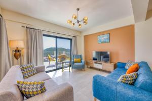 a living room with two blue couches and a tv at Çukurbağ Köyü Doğa Manzaralı Villa Oriente in Kas