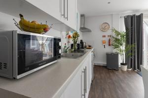 a kitchen with a counter top with a microwave at City Centre Studio Apartments - Baxter Apartment - Short Stays UK Ltd in Exeter