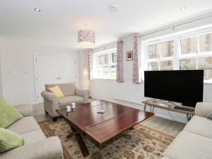 sala de estar con TV y mesa de centro en The Coach House, en Castle Cary