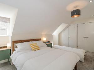 1 dormitorio con 2 camas blancas y techo en The Coach House, en Castle Cary