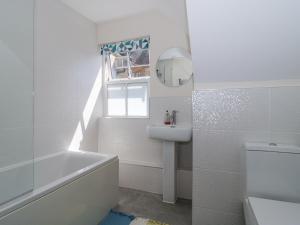 baño blanco con lavabo, bañera y ventana en The Coach House, en Castle Cary 26 fotos más