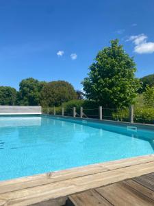 a large swimming pool with blue water at Conciergerie du château in Gevingey