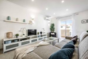 Una sala de estar con un sofá y un televisor. en Villa Simoes, en Guia