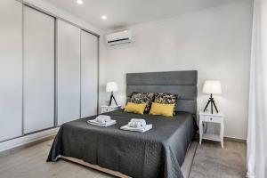 Un dormitorio con una cama grande con almohadas amarillas. en Villa Simoes, en Guia 28 fotos más