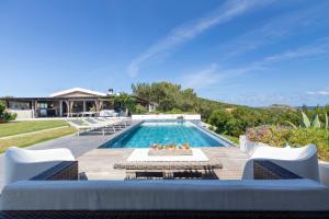 a swimming pool with chairs and a villa at Villa Altxor in Stintino