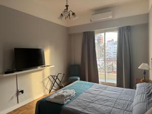 ブエノスアイレスにあるHotel Lyon by MHのベッドとテレビと窓のある寝室 +37枚の写真