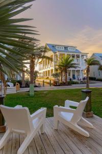 zwei weiße Stühle auf einer Terrasse vor einem Gebäude in der Unterkunft Sea Pearl 228 LAU in Mustang Beach