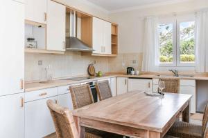 a kitchen with a wooden table and chairs at Villa Alba Minies in Minia
