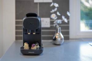 une cafetière noire assise sur un comptoir avec un vase dans l'établissement Crimon Place Townhouse - Grampian Lettings Ltd, à Aberdeen