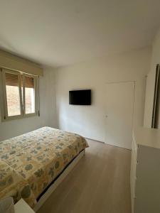 a bedroom with a bed and a tv on the wall at StayQ Appartamento elegante in centro in Castel San Pietro Terme