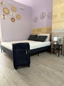1 dormitorio con 1 cama y 1 maleta en el suelo en Casa Martina, en Trani