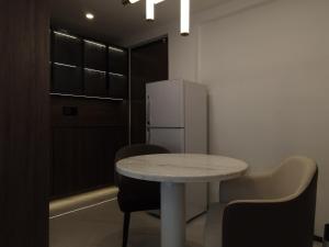 Una cocina con mesa y sillas y un refrigerador. en Vita Resort Golf Bastos, en Yaoundé