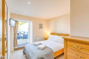 1 dormitorio con 1 cama y ventana con patio en Anzac Lookout Central Brixham Retreat with Stunning Views, en Brixham