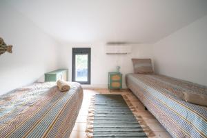 una camera da letto con due letti e una finestra di Maison du Ponton, bord de canal à Cazaux a La Teste-de-Buch