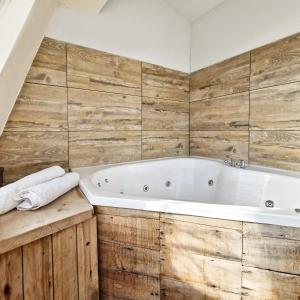 a bathroom with a white tub and wooden walls at Tirol D'andrea in Villa General Belgrano +56 photos
