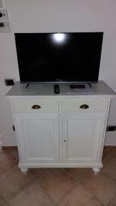 a white dresser with a flat screen tv on top at Rustic Tuscan Retreat A Cozy Escape Near Siena in Val di Pugna