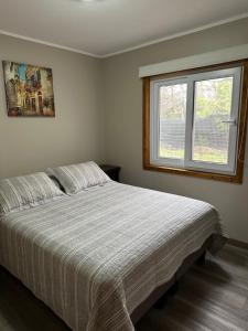 un dormitorio con una cama y una ventana en Petruleufu, en Pucón