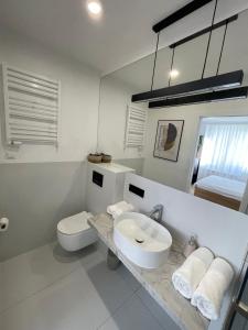 a white bathroom with a sink and a toilet at Nexiti Apartments - Centrum - Metro - Palace of Culture - Philharmonic in Warsaw