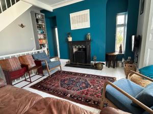ein Wohnzimmer mit blauen Wänden und einem Kamin in der Unterkunft Seacroft - 3 Bed Georgian Listed Townhouse with Wood Burning Stove in Ilfracombe
