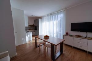 a living room with a dining room table and a television at Casa Selvaggio Blu in Santa Maria Navarrese