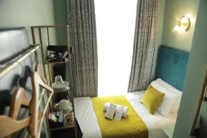 a small bedroom with a bed with towels on it at Bloomsbury Palace Hotel in London