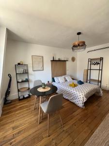 ブールジュにあるCharmant Appartement au Coeur de Bourges 24のベッドとテーブルと椅子のある寝室