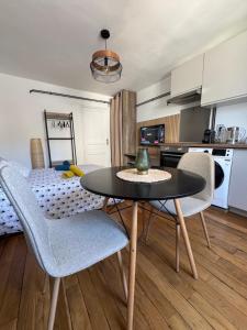 ブールジュにあるCharmant Appartement au Coeur de Bourges 24のテーブルと椅子、キッチンのあるリビングルーム